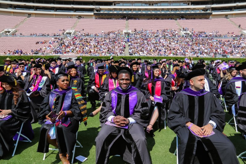 SWLAW Class of 2022 graduates seated on lawn of Rosebowl in full regalia