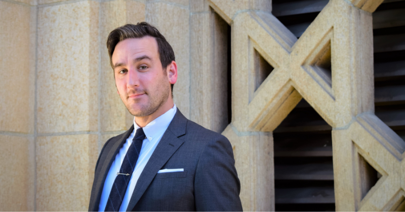 Jeff Martin headshot in dark grey suit and tie against the stone lattice of Bullocks Wilshire building