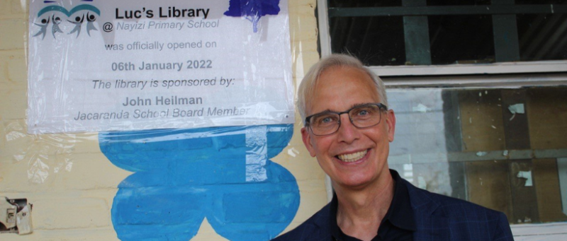 Prof. Heilman poses with sign that reads Luc's Library @ Nayizi Primary School