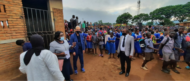 Prof. Heilman visits Malawi for the opening of a new library. He is surrounded by school children.