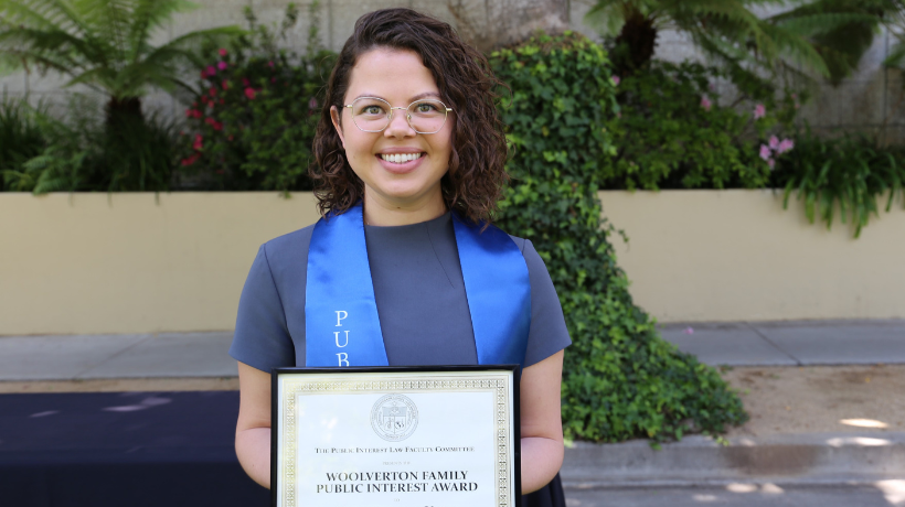 Bianca de la Vega holding up award certificate