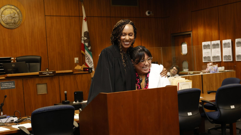 Ester Mendez hugging judge at her bar pass swearing in ceremony in courtroom