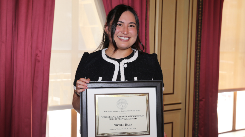 Nikki Bala holding her Woolverton Award certificate