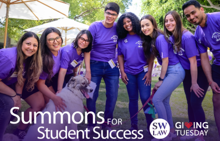 Group of Southwestern students in purple peer mentor shirts at Orientation petting a dog