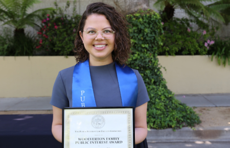 Bianca de la Vega holding up award certificate